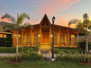 een houten huis met een straatlicht ervoor bij Villament Resort, Karjat in Karjat