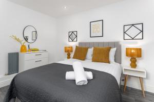 a bedroom with a bed with two towels on it at Host Liverpool - Ideal for extended stays in Walton on the Hill