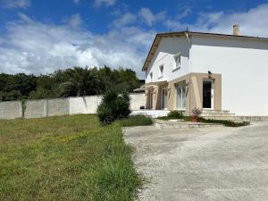 ein weißes Haus mit einem Zaun und einem Hof in der Unterkunft Apartagal-A Corredoira in Foz