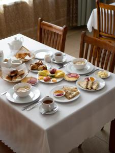 Hotel Alma-Ata في بوروفوي: طاولة بيضاء مع أطباق من الطعام وأكواب من القهوة