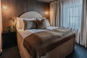 a bedroom with a large bed with pillows and a window at Funken Lodge in Longyearbyen