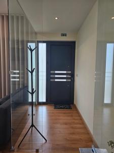 a hallway with a black door and a wooden floor at Junção - Apartamentos Completos in Miranda do Douro