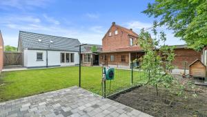 a house with a fence in a yard at An's Vakantiehuisje in Dessel