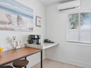 a kitchen with a desk with a coffee maker on it at Siesta By The Beach in Pompano Beach