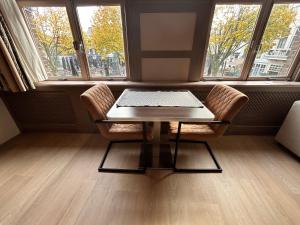 Stylish Studio S1, City Centre Dordrecht في دوردريشت: طاولة وكرسيين أمام النافذة