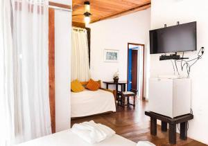 1 dormitorio con 1 cama y TV en la pared en Casa do canto, en Búzios