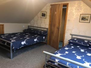 sypialnia z 2 łóżkami i drzwiami w obiekcie Number 12 Self Catering w mieście Portree