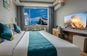 een slaapkamer met een groot bed en een bureau bij Zebulun Hotel in Lijiang