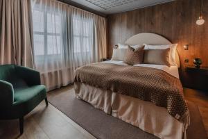 a bedroom with a bed and a chair and a window at Funken Lodge in Longyearbyen