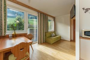 ein Wohnzimmer mit einem Schreibtisch und einem Fenster in der Unterkunft Stögergut by Schladming-Appartements in Schladming