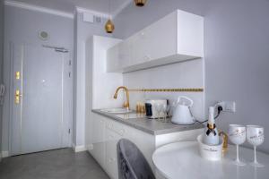 a white kitchen with a sink and a table at Lividus339 in Świnoujście