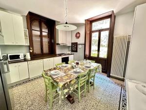 uma cozinha com uma mesa com cadeiras verdes e uma cozinha com em Villa Elisabeth em Como