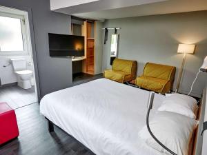 Habitación de hotel con 1 cama y 2 sillas en ibis Auxerre Sud, en Venoy