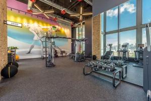 a gym with several tread machines and a mural at Luxury 2BR Corner Apt Downtown MIA in Miami