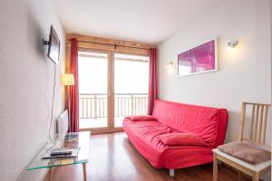 sala de estar con sofá rojo y mesa de cristal en Chalets de Florence FORET & FAMILLE appartements by AlpVision Résidences en Valfréjus