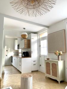 cocina con armarios blancos y techo en Charmante maison Cabourg, en Cabourg