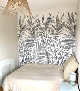 a bedroom with a bed with a black and white wallpaper at Charmante maison Cabourg in Cabourg