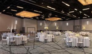 een feestzaal met witte tafels en stoelen bij Hyatt Regency Houston in Houston