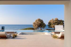 a view of the ocean from the patio of a house at Asea Villa, Spectacular right-on-the-beach Retreat, By ThinkVilla in Skaleta