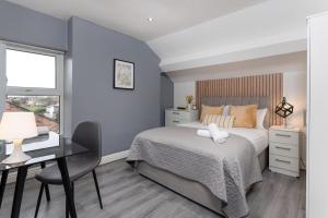 a bedroom with a bed and a desk and a window at Host Liverpool - Ideal for extended stays in Walton on the Hill