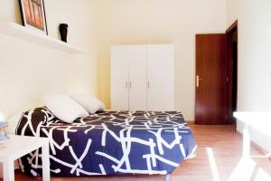 une chambre avec un lit avec une couverture bleue et blanche dans l'établissement Apartamento Cerca del Mar, à Badalona