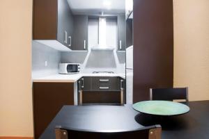 une cuisine avec une table et une cuisine avec une cuisinière dans l'établissement Apartamento Cerca del Mar, à Badalona