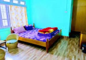 1 dormitorio con cama morada y pared azul en Hotel North Hill Arunachal Pradesh, en Tawang