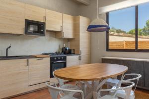 Casa de campo Masos de Pals con parking y piscina في بالس: مطبخ مع طاولة خشبية وطاولة وكراسي