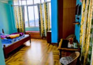 a room with a bed and a table and a window at Hotel North Hill Arunachal Pradesh in Tawang
