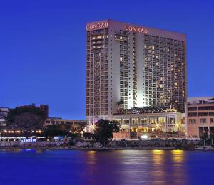 a large hotel with a sign on top of it at Conrad Cairo Hotel & Casino in Cairo