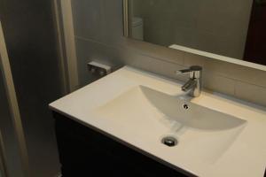 une salle de bains avec un lavabo blanc et un miroir dans l'établissement Apartamento Cerca del Mar, à Badalona 26 autres photos