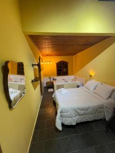 a hotel room with two beds and a mirror at Cipó Hostel in Serra do Cipo