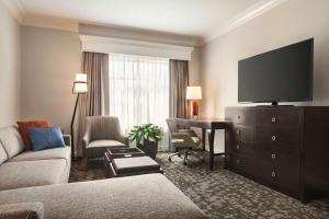 基西米Embassy Suites by Hilton Orlando Lake Buena Vista South的客厅里有一张沙发和一张带电视的书桌
