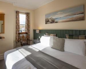 a bedroom with a large bed and a window at Castle Court in Beaumaris