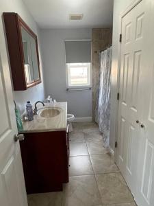 a bathroom with a sink and a toilet at NYC Adjacent Comfy 9 Guest Home in Passaic