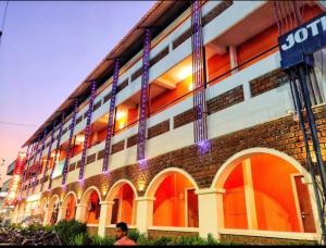 Un hombre parado frente a un edificio de ladrillos en A K Residency, en Kālapettai