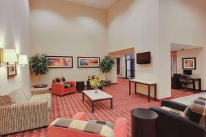 a lobby with couches and chairs and a television at Ramada Inn by Wyndham Fairfield NJ in Fairfield