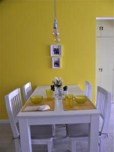 a dining room table with white chairs and yellow walls at Crespo Apartament Premiun in Buenos Aires