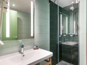 bagno con lavandino e specchio di Ibis Styles Paris Gare Saint Lazare a Parigi