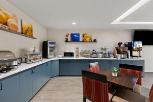 cocina con armarios azules y mesa de madera en Comfort Inn Powell - Knoxville North, en Knoxville