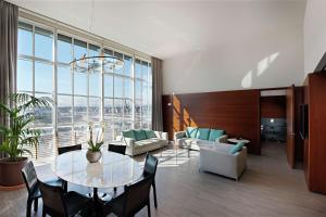 uma sala de estar com mesa e cadeiras em DoubleTree by Hilton Turin Lingotto em Turim