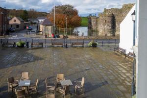 a group of chairs and tables in a courtyard with a castle at Castle Court in Beaumaris