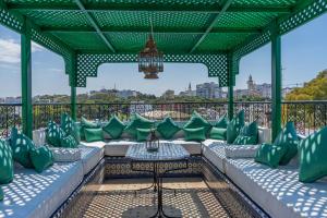 a pergola with green and white pillows on a patio at Lalla Soulika in Tangier