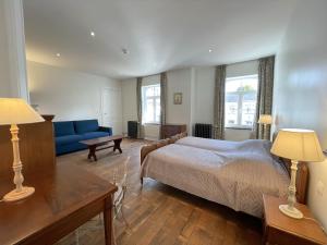 1 dormitorio con 1 cama y 1 sofá azul en Les Hys de Verdenne, en Marche-en-Famenne
