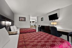 a hotel room with two beds and a desk at Econo Lodge Princess Anne in Princess Anne +12 photos