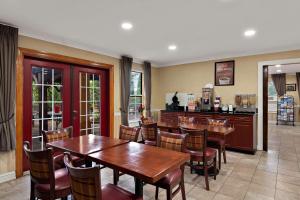 Econo Lodge في Princess Anne: غرفة طعام مع طاولات وكراسي خشبية