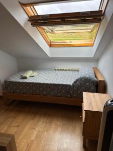 a bedroom with a bed with a skylight at Pilgrim’s House in O Pedrouzo