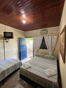 um quarto com 2 camas, uma televisão e uma janela em PANTANAL SANTA CLARA em Corumbá