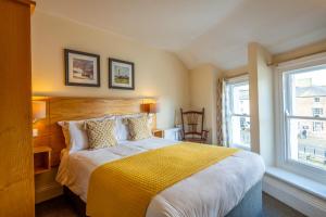 a bedroom with a large bed with a yellow blanket at Castle Court in Beaumaris