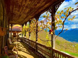 a porch of a house with a view of the mountains at Gentry House in Ambrolauri